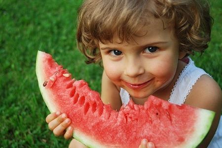 Niña comiendo sandía con sulfato de potasio